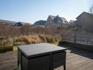 a black bench sitting on a wooden deck at Plaza A1A02 located on the dunes in Oostduinkerke
