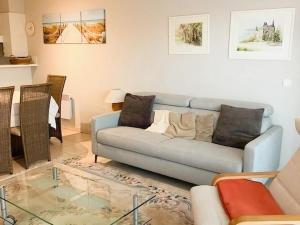a living room with a couch and a glass table at Plaza A1A02 located on the dunes in Oostduinkerke