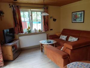 a living room with a couch and a tv at Holiday home Kobel in Elmstein