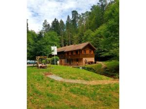 a log cabin in the woods with a playground at Holiday home Kobel in Elmstein