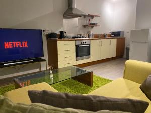 un soggiorno con TV e cucina di Stylish City Centre Apartment by Cloud Suites a Manchester