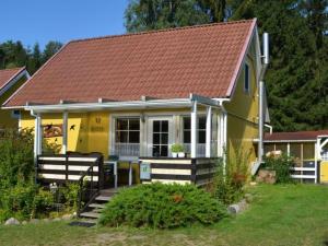 una pequeña casa amarilla con techo rojo en Holiday home Angel 2, en Warin