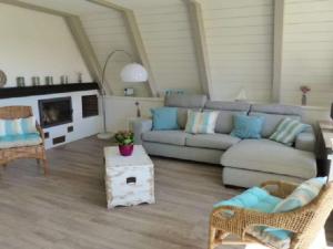 a living room with a couch and chairs and a fireplace at Holiday home Sehnsucht Schlei in Brodersby