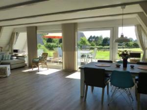 a living room with a table and chairs and a living room at Holiday home Sehnsucht Schlei in Brodersby