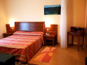 una camera da letto con un letto e due comodini di Hotel Due Pini a Melfi Altre 37 foto