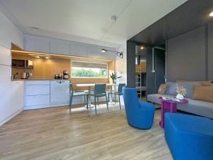 a kitchen and a living room with a table and chairs at Tiny house with lake view in holiday village in Bavaria in Neunburg vorm Wald