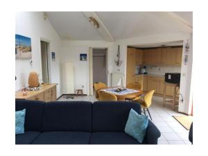 a living room with a couch and a table and a kitchen at Holiday home Seestern 283 in De Zandloper