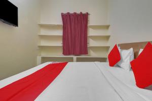 1 dormitorio con 1 cama con almohadas rojas y blancas en 80983G RBS Square Langer Houz en Haidar Sāhibgūda