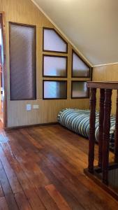 a room with two beds in a room with windows at Cygnus Hostel in Valdivia