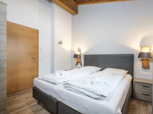 een slaapkamer met een groot bed met witte lakens bij Luxury Tauern Suite Walchen Kaprun 8 in Angerberg