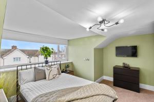 a bedroom with a bed and a flat screen tv at Birkenhead Aparthotel in Rock Ferry