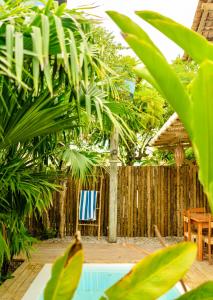 a backyard with a swimming pool and a wooden fence at Villa Joá - Casa in Trancoso