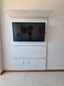una TV a schermo piatto su una parete bianca di Apartamento frente mar praia do flamengo a Salvador