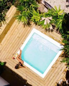 a woman laying on a deck next to a swimming pool at Villa Joá - Casa in Trancoso