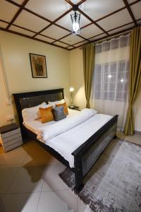 ein Schlafzimmer mit einem großen Bett in einem Zimmer in der Unterkunft Entire 3-Bedroom Holiday Home in Kampala, Lovingly Furnished in Kampala