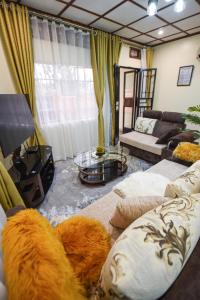 a living room with two couches and a table at Entire 3-Bedroom Holiday Home in Kampala, Lovingly Furnished in Kampala