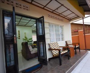 ein Wohnzimmer mit einem Tisch und Stühlen im Zimmer in der Unterkunft Entire 3-Bedroom Holiday Home in Kampala, Lovingly Furnished in Kampala