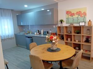 a kitchen with a table with a vase of flowers on it at Garden House Fundão - Suíte 203 in Fundão