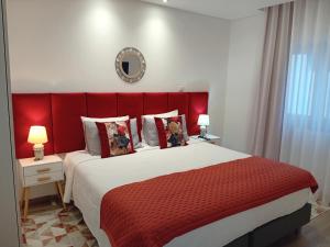 een slaapkamer met een groot bed met een rood hoofdeinde bij Garden House Fundão - Suíte 203 in Fundão