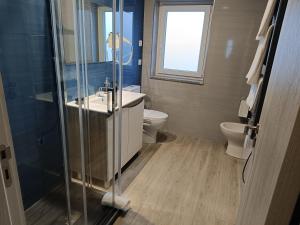 a bathroom with a shower and a sink and a toilet at Garden House Fundão - Suíte 203 in Fundão