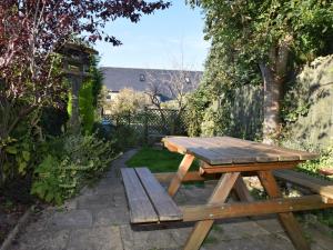 - une table de pique-nique en bois et un banc dans le jardin dans l'établissement 3 Bed in Whitley Bay CN013, à Backworth