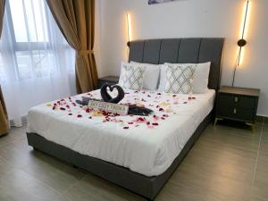 um quarto com uma cama grande com flores em SKY COZY TROIKA RESIDENCE, 1 BEDROOM 4-6 PAX, 2 BEDROOMS 6-8 PAX, POOL VIEW, SKY & CITY VIEW, Free Parking, Pool, WiFi, Netflix, Disney Hotstar em Kota Bharu