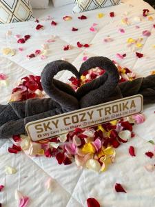 dois cisnes a fazer um coração numa cama com flores em SKY COZY TROIKA RESIDENCE, 1 BEDROOM 4-6 PAX, 2 BEDROOMS 6-8 PAX, POOL VIEW, SKY & CITY VIEW, Free Parking, Pool, WiFi, Netflix, Disney Hotstar em Kota Bharu