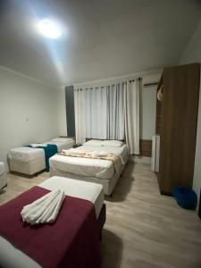 a hotel room with three beds in it at Pousada Estrela Dalva in Penha