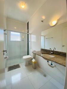 La salle de bains est pourvue d'une douche, d'un lavabo et de toilettes. dans l'établissement Suíte privativa proxima ao Sesc 2, à Bertioga