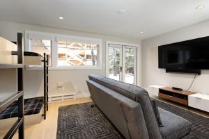 un soggiorno con divano e TV a schermo piatto di Fasching Haus Unit 7, Luxury Condo with Designer Decor, Ideal Location, Common Pool & Hot Tub ad Aspen