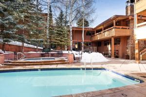 uma piscina em frente a uma casa em Fasching Haus Unit 7, Luxury Condo with Designer Decor, Ideal Location, Common Pool & Hot Tub em Aspen