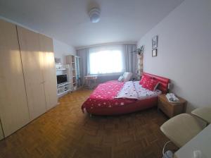 1 dormitorio con cama roja y ventana en Влюбленные, en Viena
