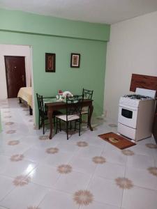 a kitchen with a table and chairs and a stove at Willow tree quiet and peaceful in Montego Bay