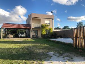 uma casa com uma cerca e um quintal em Casa das Maria Praia do Laranjal em Pelotas