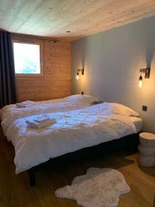 a bedroom with a bed with white sheets and a window at Superbe chalet avec vue montagne in Orcières