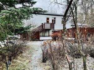 Dieses weiße Haus verfügt über eine Veranda und einen Balkon. in der Unterkunft Large villa with hot tub and sauna in Mosfellsbær