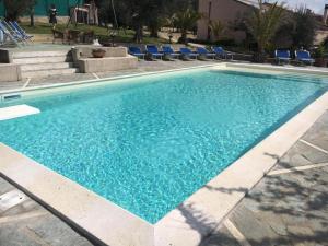 a large blue swimming pool with blue lounge chairs at Villa Graziella Perugia in Perugia