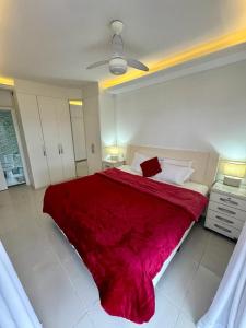 um quarto com uma cama grande e um cobertor vermelho em Flat Mar Montanha Four Seasons no Rio de Janeiro