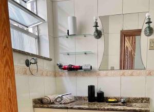 een badkamer met een spiegel en een föhn op een aanrecht bij Apartamento Inteiro na Praia de Icaraí com Vista in Niterói +26 foto's