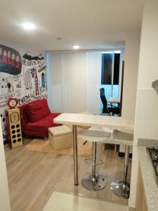 ein Wohnzimmer mit einem Tisch und einem roten Sofa in der Unterkunft Apartamento céntrico en Manizales, costo por noche $125.000 in Manizales