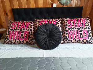 a bed with pink and black pillows and a black ball on it at Cabañas costa maule in Constitución