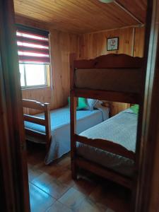 1 dormitorio con 2 literas y ventana en Cabañas costa maule en Constitución
