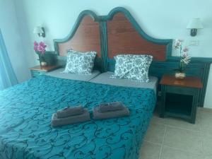 een slaapkamer met een groot blauw bed met 2 kussens bij Sunset apartment in El Guincho