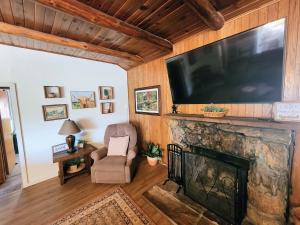 a living room with a large flat screen tv above a fireplace at Lazy Oaks Resort in Pinetop-Lakeside