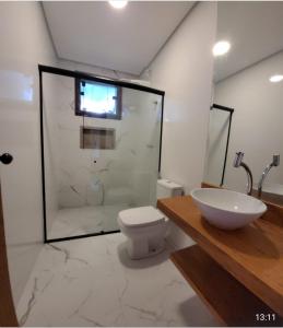 a bathroom with a shower and a toilet and a sink at Casa Alto do Campo - Lavras Novas MG in Lavras Novas +8 photos