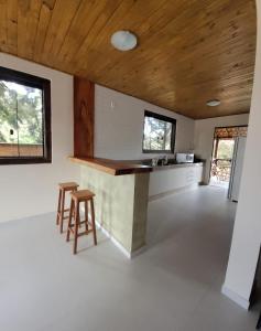 a kitchen with a counter and stools in a room at Casa Alto do Campo - Lavras Novas MG in Lavras Novas