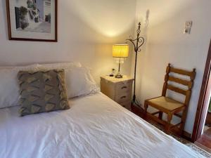 - une chambre avec un lit doté d'une lampe et d'une chaise dans l'établissement Sylvia's House - a unique waterfront location, à Kokkari