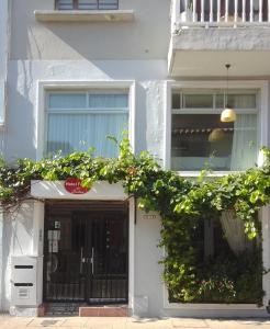 uma casa branca com uma porta preta e janelas em Hotel Fegali Art Boutique em Cartagena das Índias