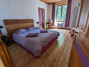 a bedroom with a large bed and wooden floors at Gîte Le Chambon-sur-Lignon, 9 pièces, 15 personnes - FR-1-582-21 in Le Chambon-sur-Lignon