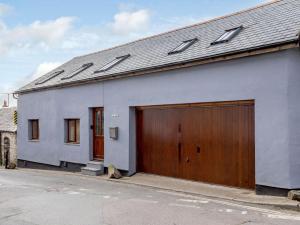 una casa bianca con due porte del garage e una strada di 3 Bed in Braunton 86704 a Braunton